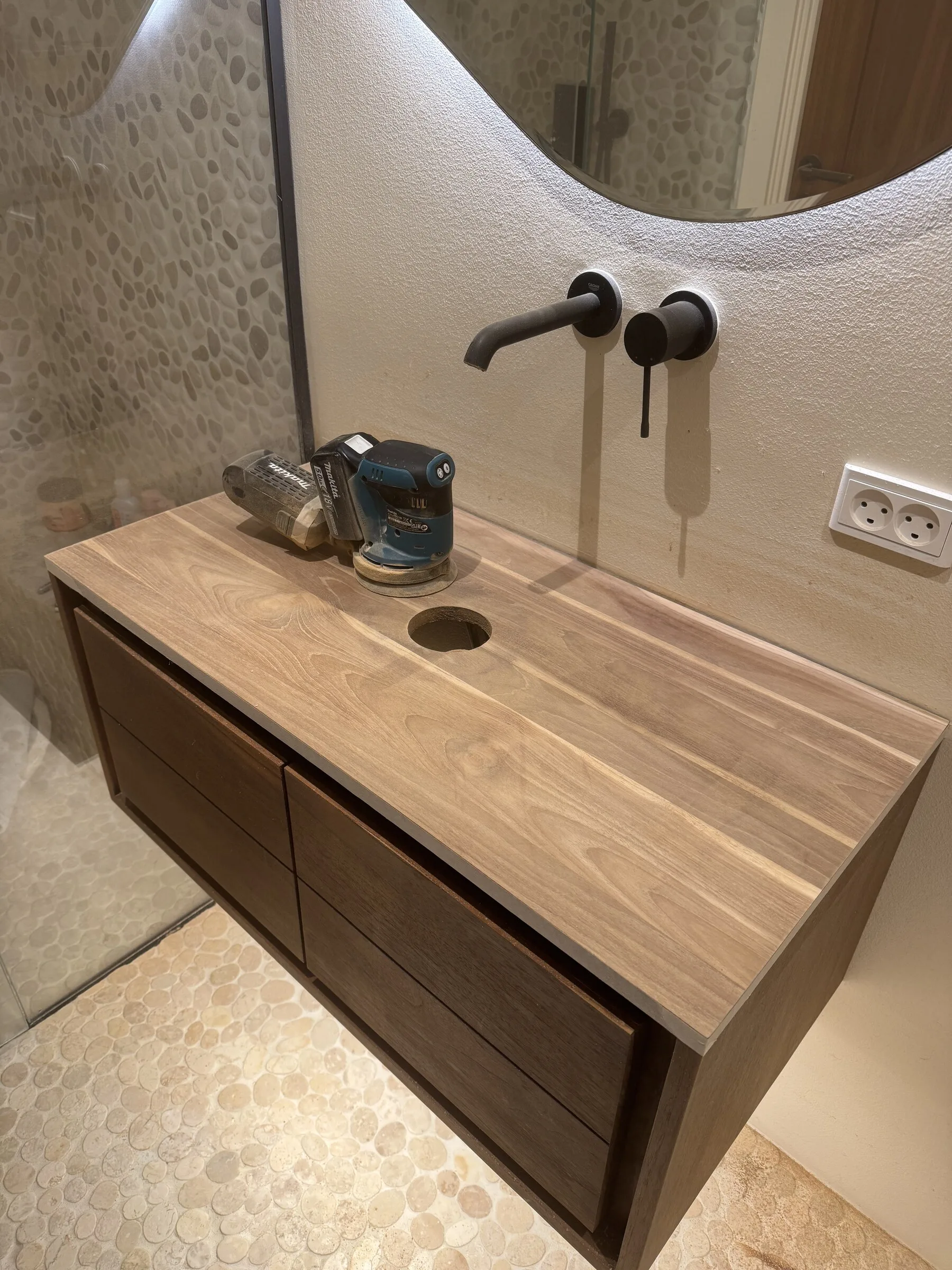 Bathroom vanity top during sanding, with the worn finish being removed before oiling