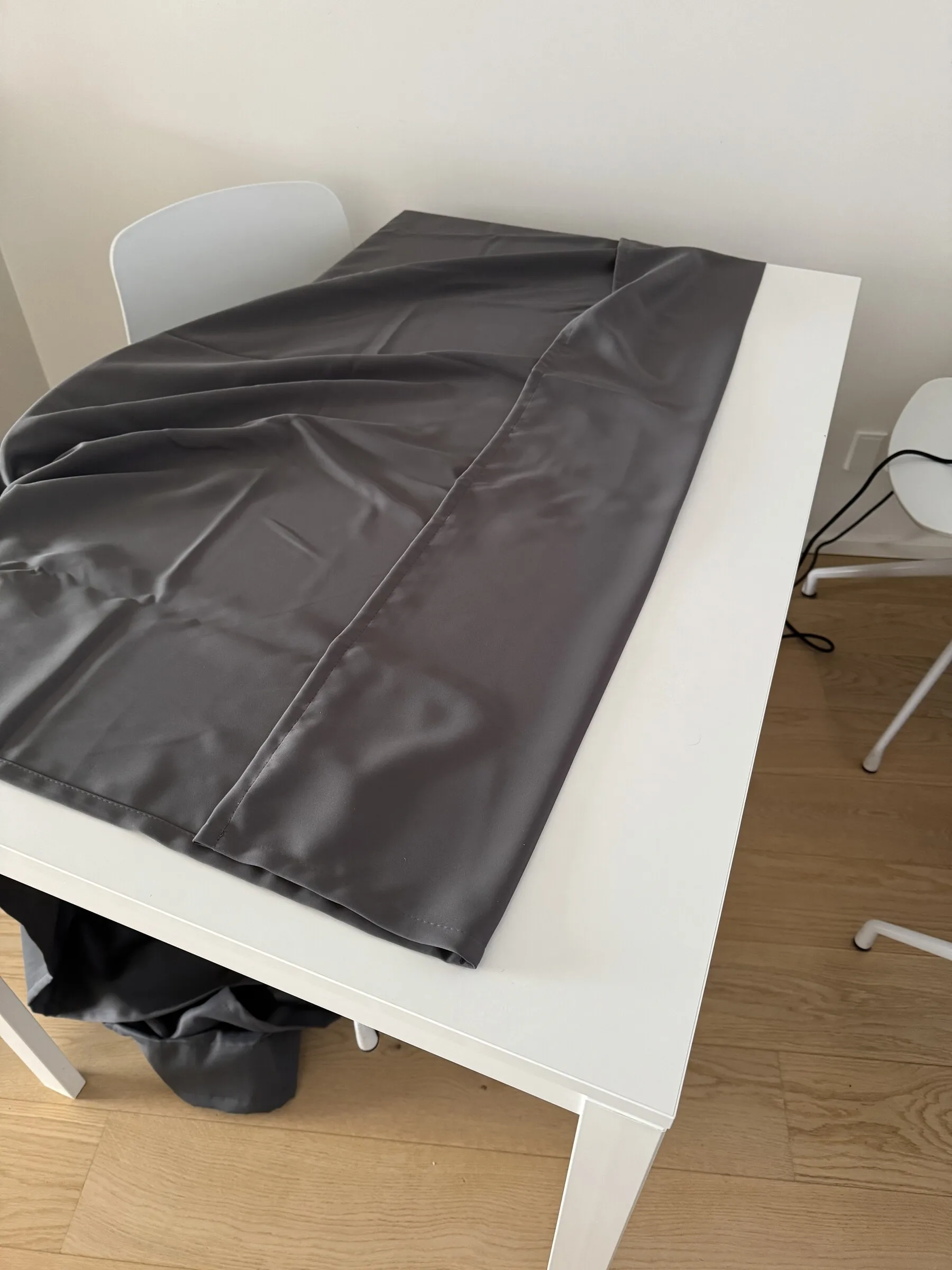 Curtain fabric being adjusted and hemmed during a representative recent installation example