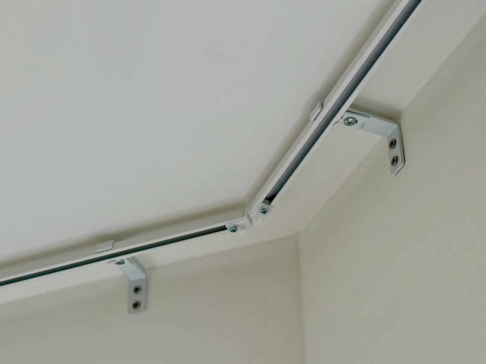 Ceiling-mounted corner curtain rail installation