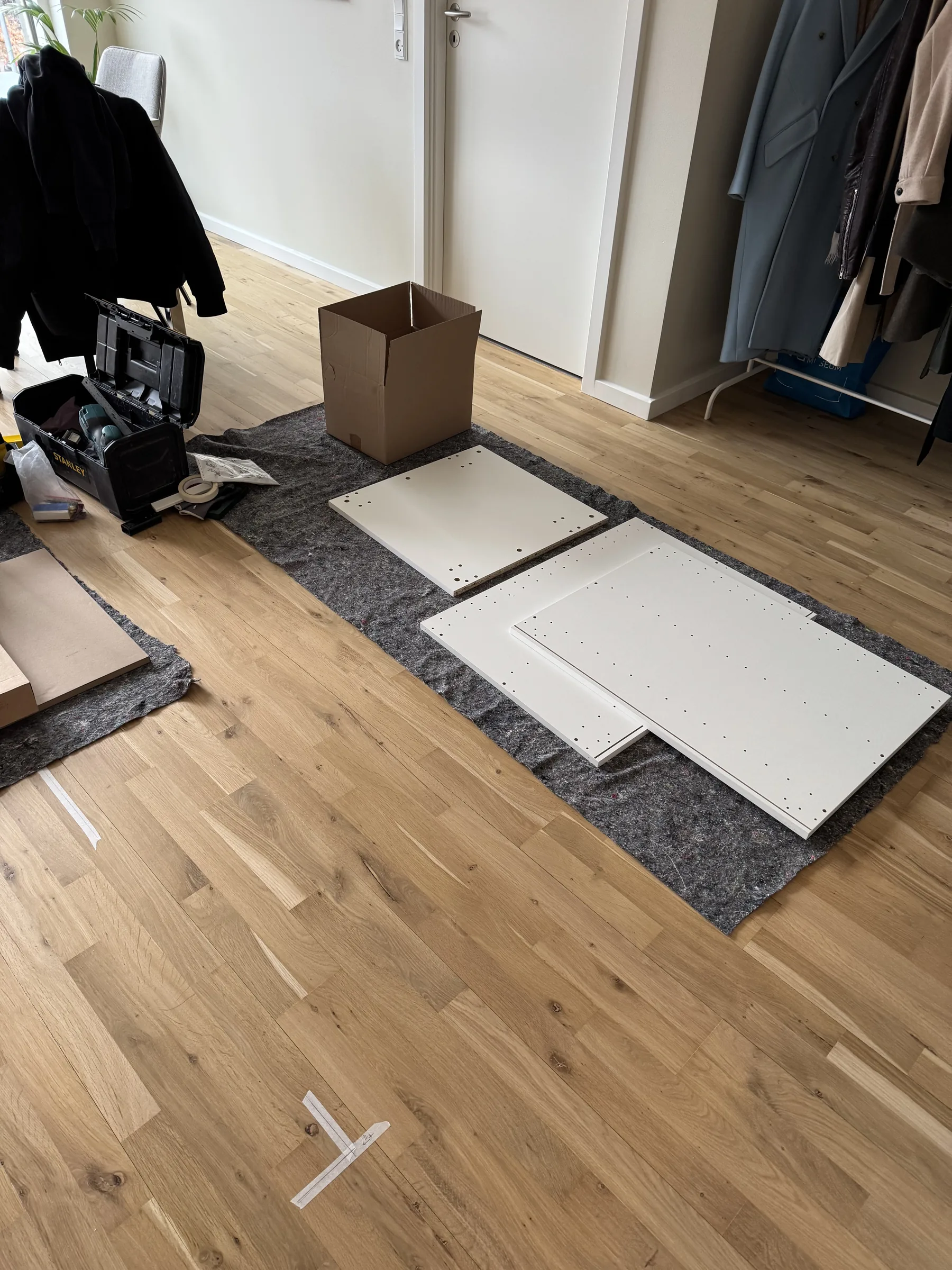 Typical prep stage with flat-pack panels and parts laid out before IKEA assembly