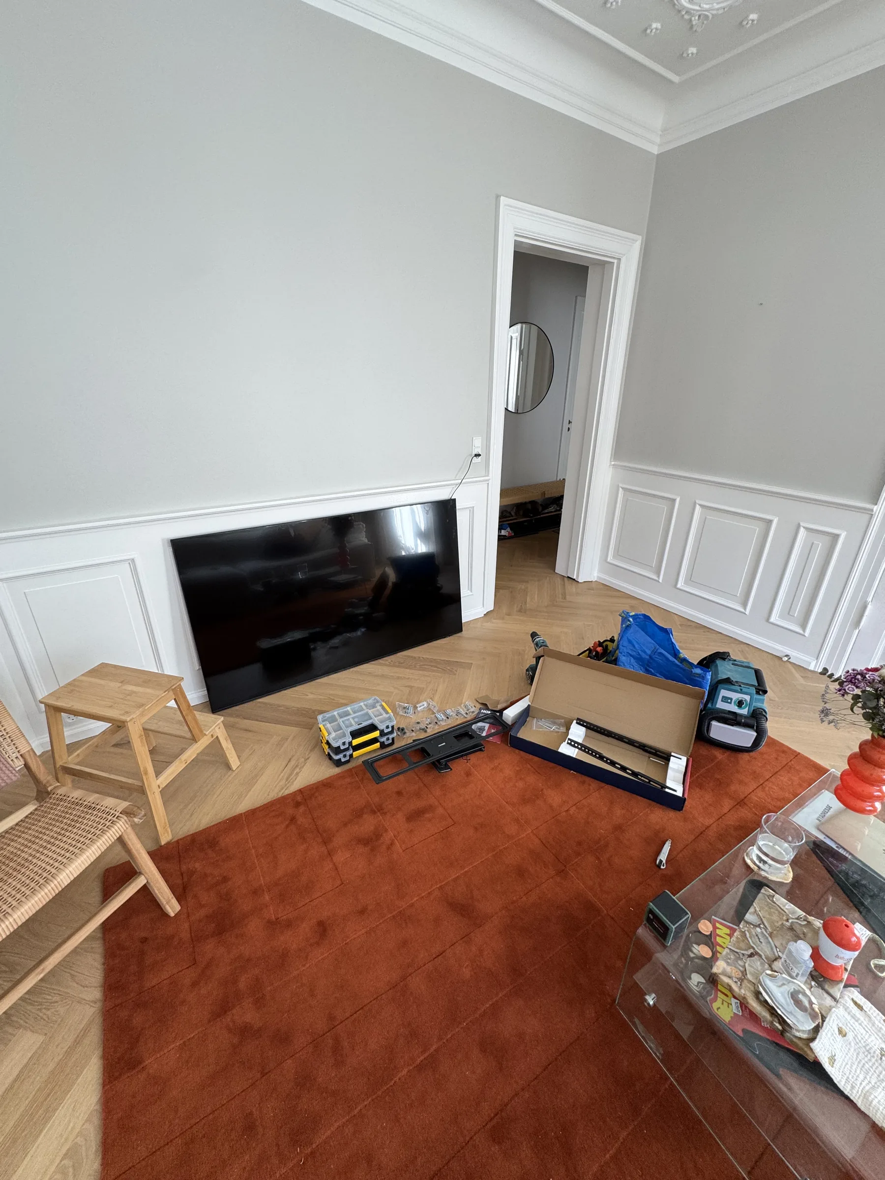 TV resting on the floor before wall mounting in a Copenhagen apartment living room
