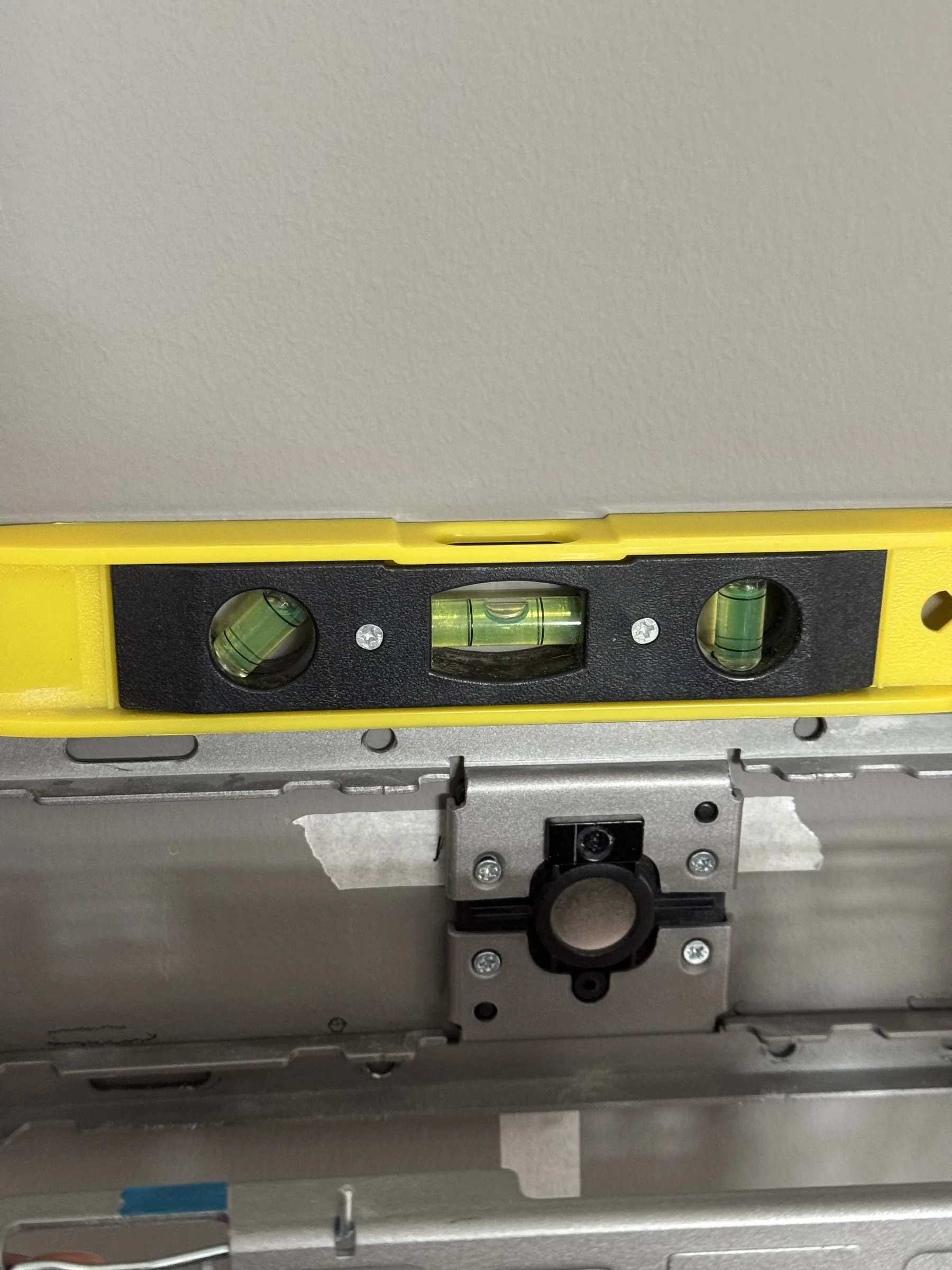 Spirit level checking the TV wall bracket during installation
