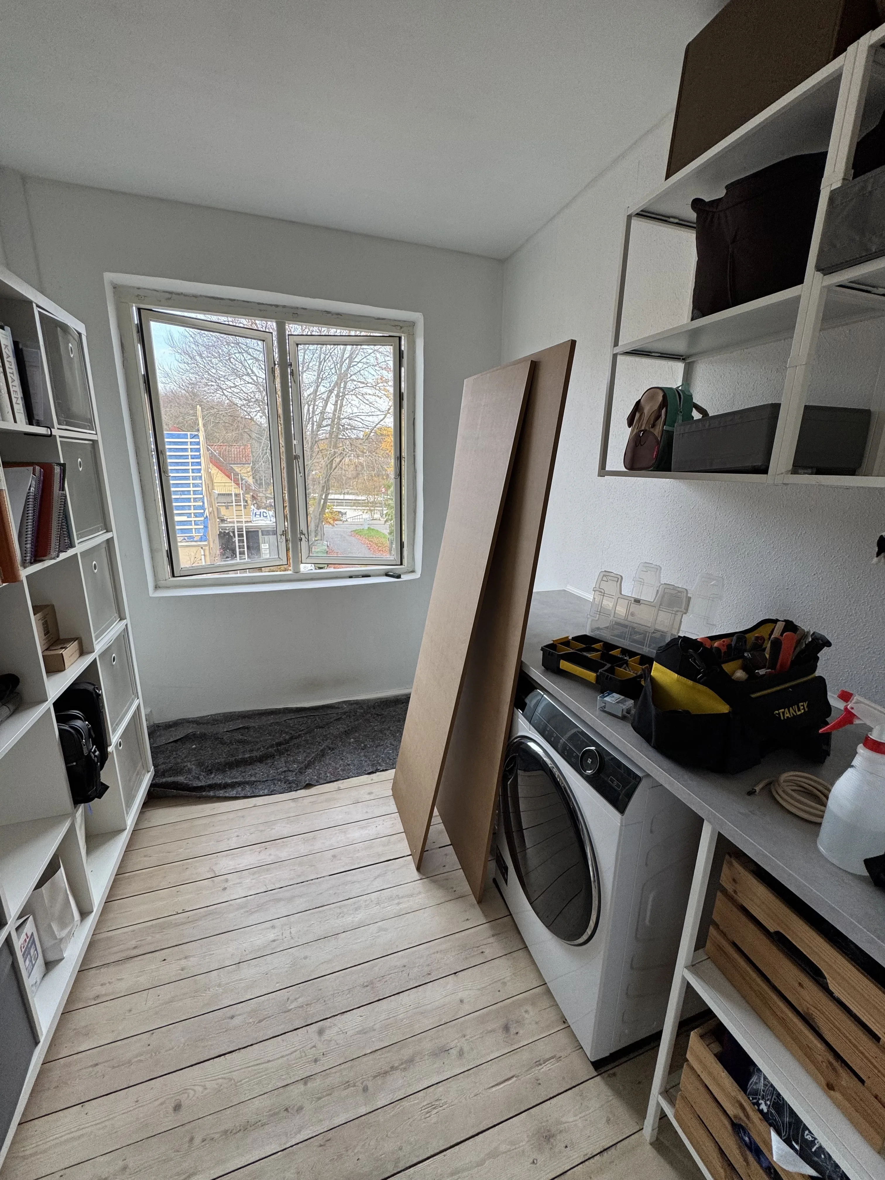 Window opening before final trim fitting, with trim boards ready in the room