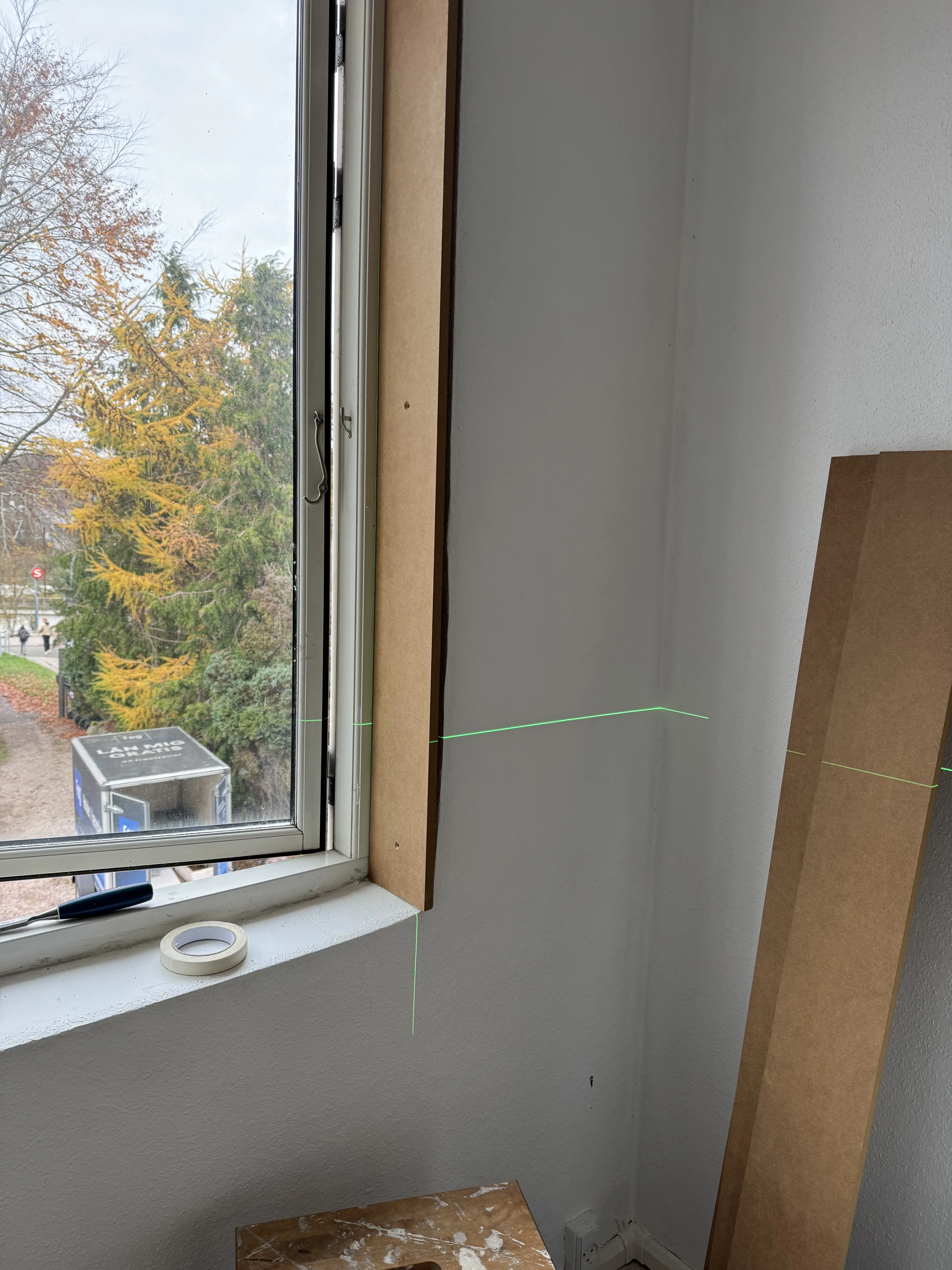 Trim fitting in progress with laser lines marking the window surround